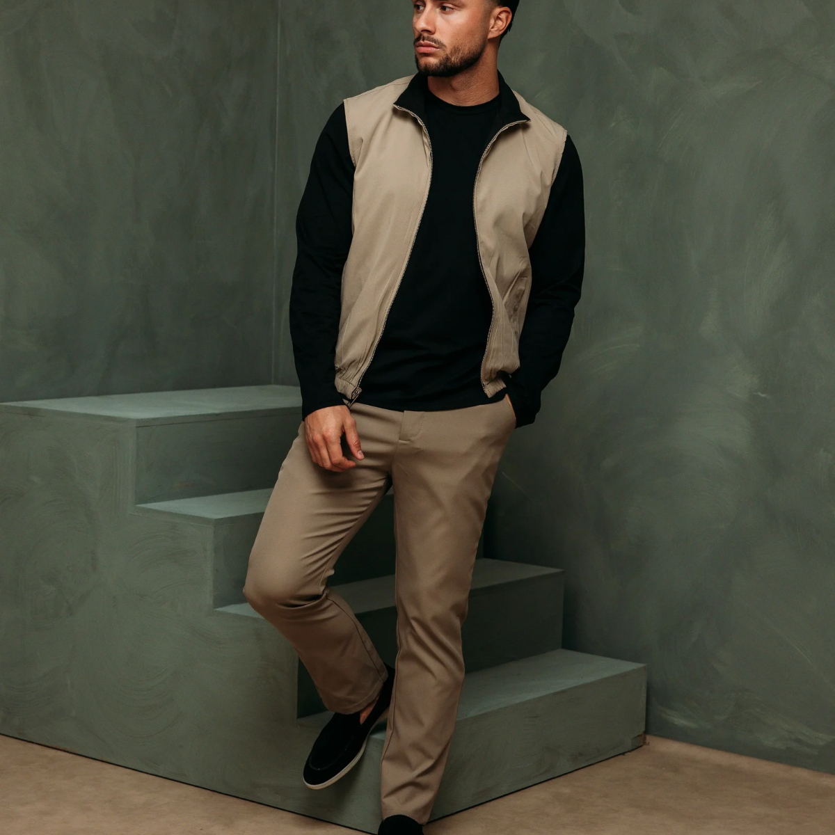Model op een trap in de Core Bodywarmer Black Beige met de beige kant buiten